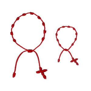 May include: Two red knotted rope bracelets with a cross at the end. The larger bracelet has a circle of knots and the smaller bracelet has a smaller circle of knots.
