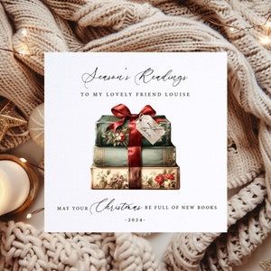 May include: A Christmas greeting card with the text "Season's Readings" and "To my lovely friend Louise". The card features a stack of vintage books tied with a red ribbon and a tag that says "with love". The card also says "May your Christmas be full of new books -2024-".