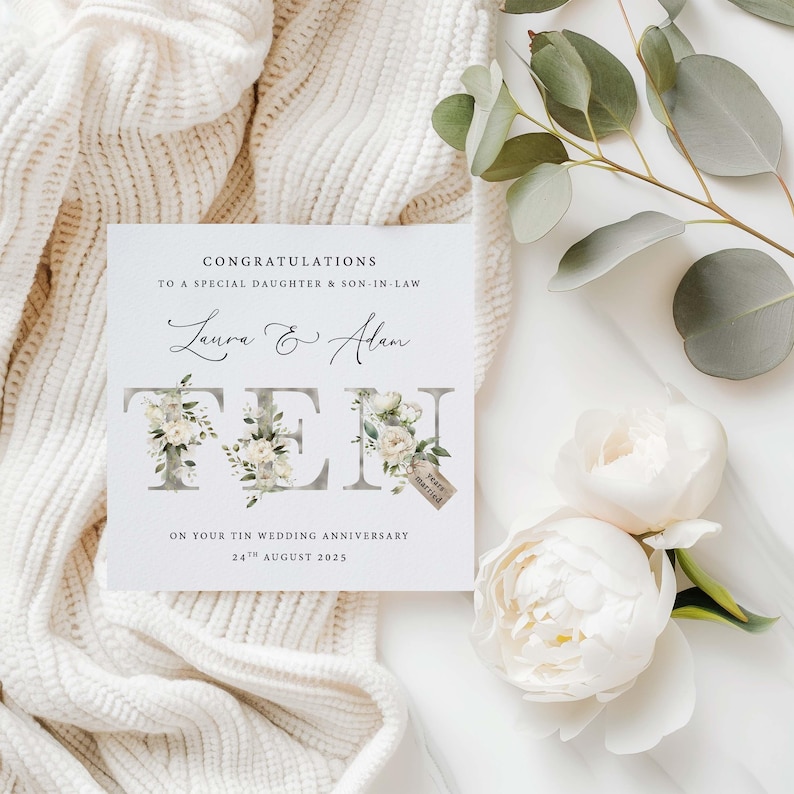 May include: A white card with a floral design and the text "Congratulations to a special daughter & son-in-law Laura & Alan Ten years married On your Tin Wedding Anniversary 24th August 2025"
