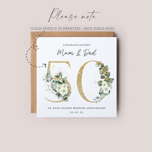 May include: A white card with gold lettering and green foliage surrounding the number 50. The card reads "Congratulations Mum & Dad on your Golden Wedding Anniversary 22.07.23".