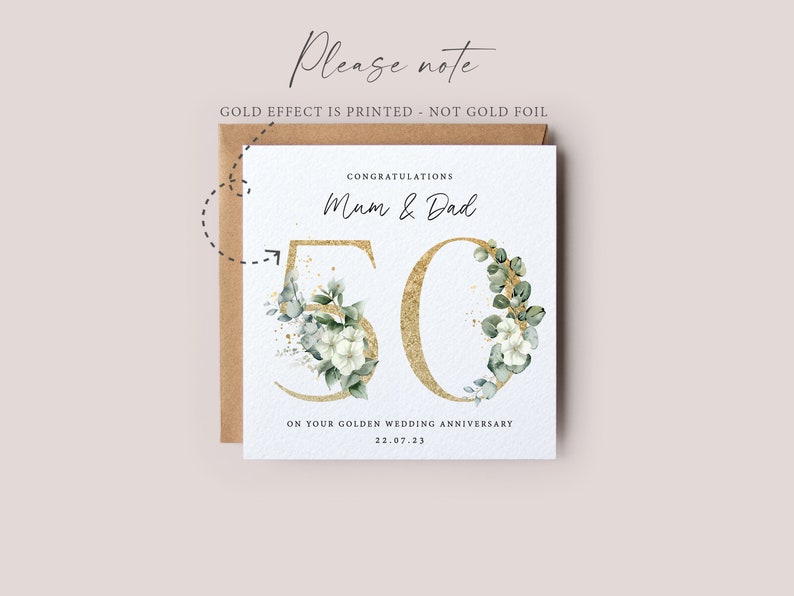 May include: A white card with gold lettering and green foliage surrounding the number 50. The card reads "Congratulations Mum & Dad on your Golden Wedding Anniversary 22.07.23".