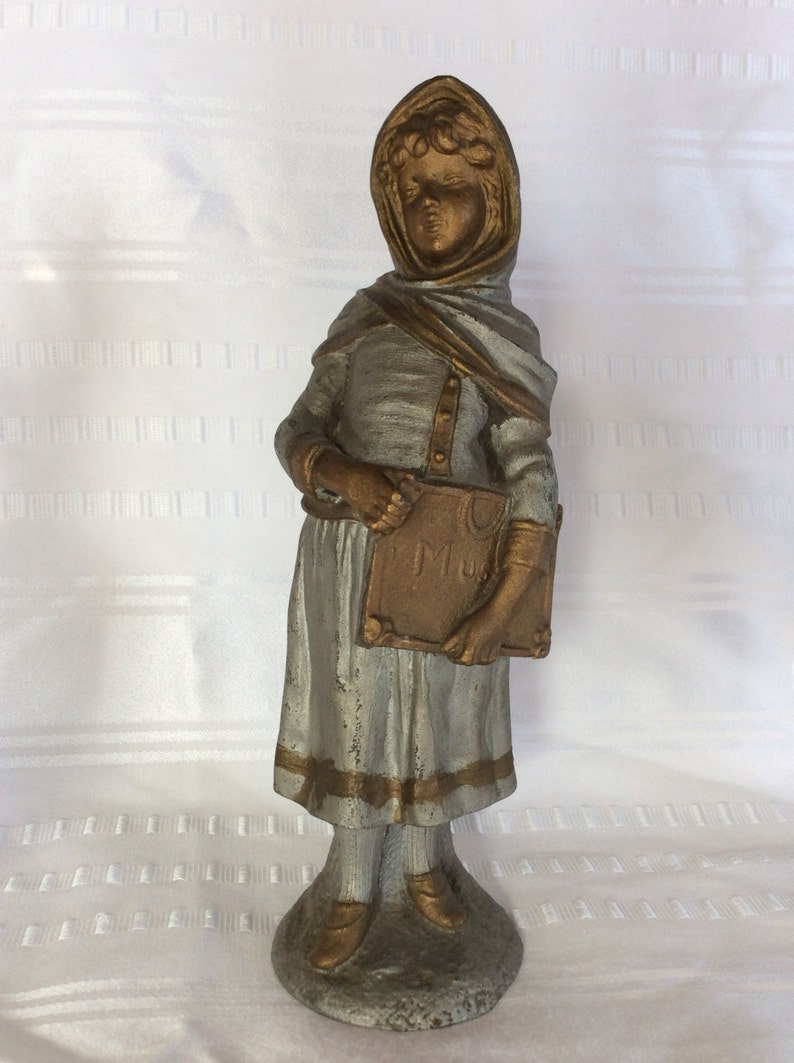 Antique white metal girl statue figurine going to her music lesson