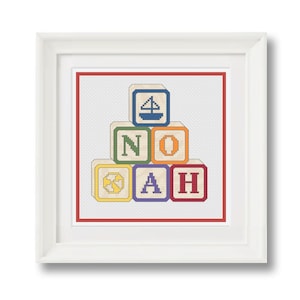 Puede incluir: Un diseño de punto de cruz enmarcado que presenta una pila de bloques coloridos que deletrean el nombre "NOAH". El bloque superior tiene un diseño de velero, y los otros bloques tienen una estrella, un círculo, una letra A y una letra H.