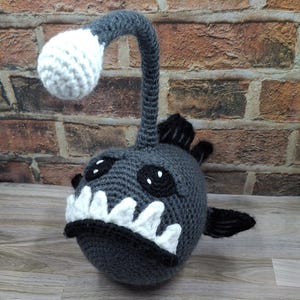 Grande peluche amigurumi all&#39;uncinetto a forma di rana pescatrice con esca fosforescente