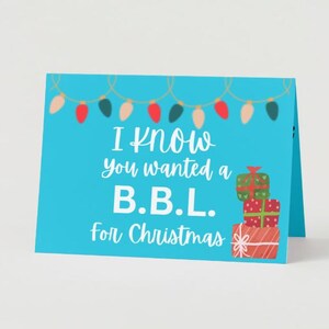 May include: A blue Christmas card with a string of lights and the text "I know you wanted a B.B.L. for Christmas" and a stack of wrapped presents.