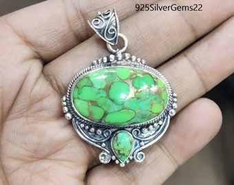 May include: A silver pendant with a green turquoise stone set in an oval shape. The pendant has intricate silver detailing and a bail for attaching a chain.