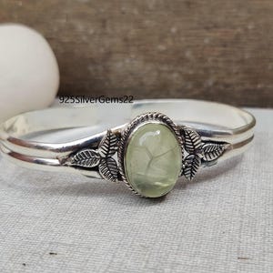 Könnte beinhalten: Silberarmband mit einem grünen Edelstein und Blattverzierungen. 925SilverGems22.