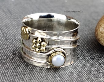 Könnte beinhalten: Ein drehbarer Silber- und Goldring mit einem weißen Opal-Stein und einem Blattdesign. 925silvergems22