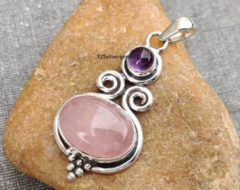 Könnte beinhalten: Ein silberner Anhänger mit einem rosafarbenen Rosenquarz und einem violetten Amethyst. Der Anhänger hat ein filigranes, verziertes Design mit Spiralen und einem Perlendetail.