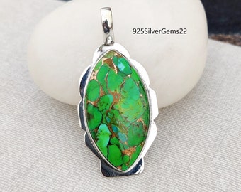 May include: A silver pendant with a green and brown turquoise stone set in a marquise shape. The pendant has a scalloped edge and a bail for attaching a chain.