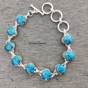 May include: A turquoise and silver bracelet with a toggle clasp. The bracelet features round turquoise stones with a marbled pattern.