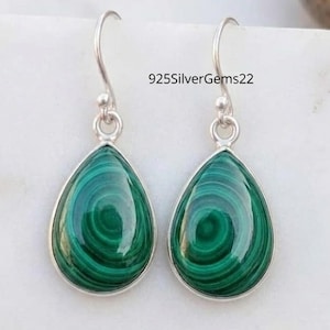 May include: A pair of silver earrings with teardrop-shaped malachite stones. The malachite has a swirling green pattern. The earrings have a simple hook design. The text "925SilverGems22" is visible.