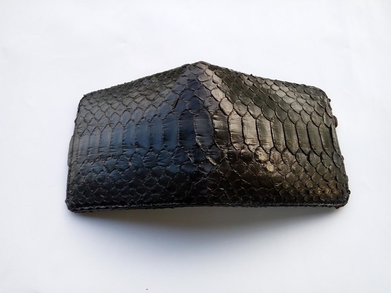 May include: A black leather wallet with a snakeskin pattern.