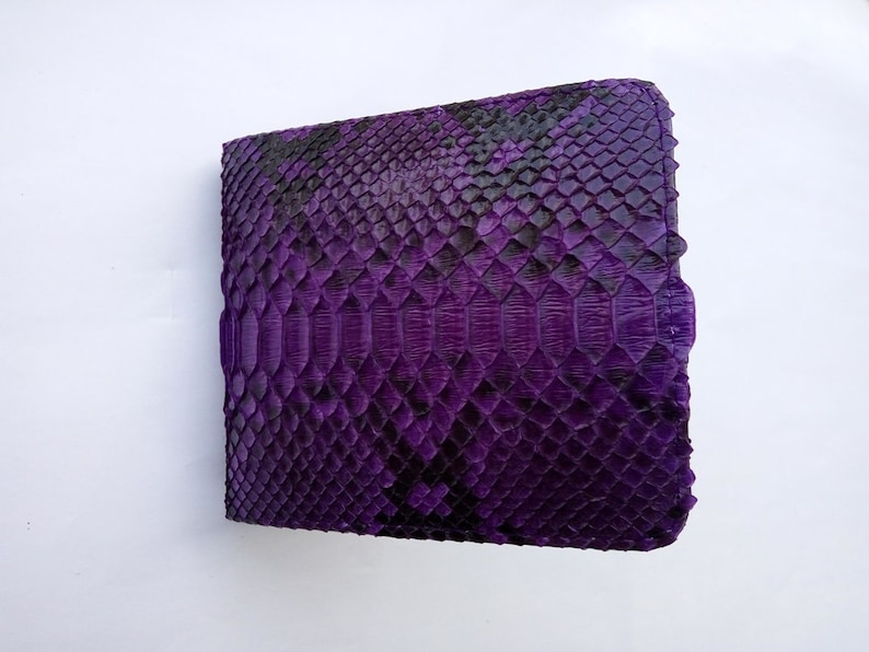 May include: A purple snakeskin wallet with a textured pattern.