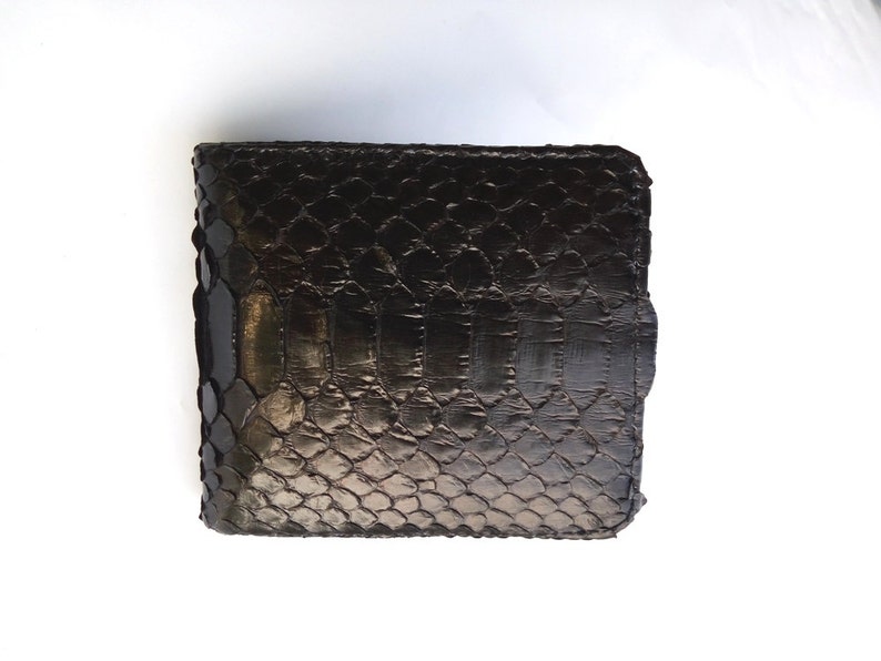 May include: A black leather wallet with a snakeskin pattern.