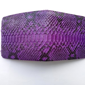 May include: A purple snakeskin wallet with a textured pattern.