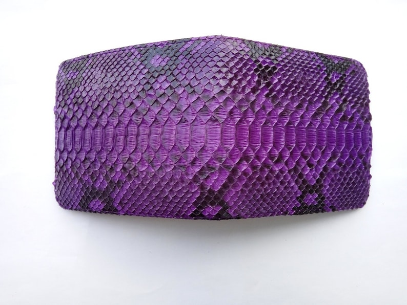 May include: A purple snakeskin wallet with a textured pattern.