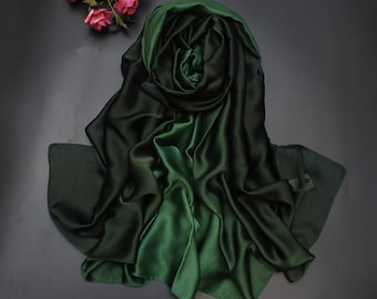 May include: A solid dark forest green scarf with a smooth, satin-like finish and a soft, draped texture. The fabric displays subtle light reflections across its folds, creating a deep, rich color appearance throughout the entire rectangular piece.