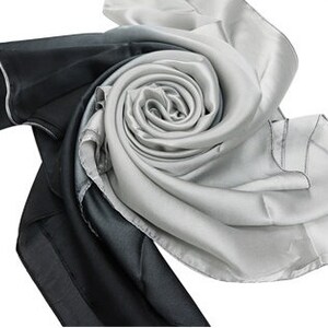 May include: A black and white silk scarf with a gradient pattern. The scarf is folded into a rose shape.
