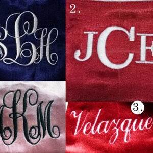 May include: Three examples of embroidery on fabric. The first example is a white monogram "SLH" on a dark blue background. The second example is a white monogram "JCE" on a red background. The third example is a white name "Velazquez" on a red background.