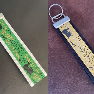 May include: Three Harry Potter themed keychains with black, white, and blue fabric straps. The straps have gold lettering that reads "Don't Let the Muggles Get You Down".