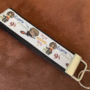 May include: Black and white key chain with a white ribbon featuring Harry Potter characters, the text "You are a wizard Harry", and the text "Expecto Patronum 9 3/4".