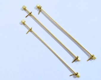 May include: Three wooden dowels with gold-colored metal screw-on ends. The dowels are approximately 12 inches long.