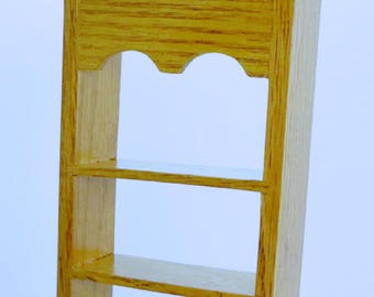 May include: A wooden wall shelf with five shelves and a decorative top. The shelf is made of light wood with a natural finish.
