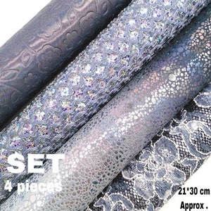 May include: Set of four rolls of decorative fabric in shades of gray. The fabrics feature different patterns, including a textured design, a sparkly design, a speckled design, and a lace design. The rolls are labeled "SET 4 pieces" and "21*30 cm Approx."