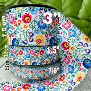 May include: Four rolls of white ribbon with a colourful floral pattern. The ribbon widths are 7/8 inch, 1.5 inches, 3 inches, and 7.5 cm.