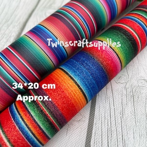 May include: Two rolls of colorful fabric with a striped pattern reminiscent of a Mexican serape. The fabric is approximately 34 inches by 20 inches. The text "Twincraftsupplies" is visible on the fabric.