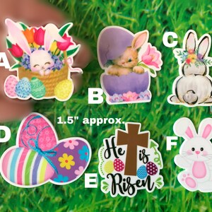 May include: Six Easter-themed stickers featuring bunnies, eggs, and a cross with the text "He is Risen". The stickers are approximately 1.5 inches in size.