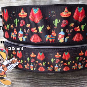 May include: Two rolls of black ribbon featuring a Mexican-themed design. The pattern includes sombreros, ponchos, cacti, and the words "Viva Mexico". The top ribbon is 38 mm wide, and the bottom ribbon is 22 mm wide.