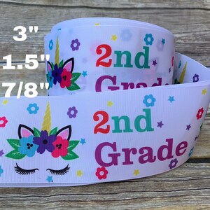 May include: White ribbon with a unicorn design and the text "2nd Grade" in rainbow colors. The ribbon is available in 3", 1.5", and 7/8" widths.