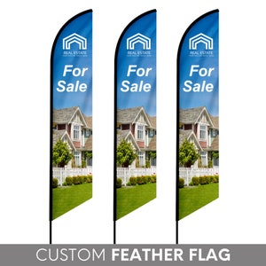 May include: Three custom feather flags with a blue background and a house image. The flags have the text "REAL ESTATE" and "For Sale" printed on them.