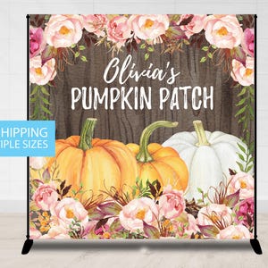 May include: A backdrop featuring a watercolor design with the text "Olivia's Pumpkin Patch." The design includes orange and white pumpkins, pink flowers, and green foliage against a wood-grain background.