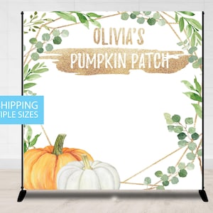 May include: A white backdrop with a gold geometric frame and green watercolor leaves. The text "Olivia's Pumpkin Patch" is written in gold glitter font. Two pumpkins, one orange and one white, are at the bottom of the backdrop.