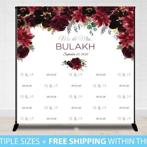 May include: A white backdrop with burgundy floral accents and the text "Mr. & Mrs. BULAKH September 25, 2020". The backdrop is designed for a wedding or engagement photo booth.