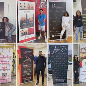 May include: A collection of retractable banner stands featuring various businesses and brands. The banners display logos, text, and images, including "Prosperity," "Glory," "Duxurious Beauty," "Krissy's Kandles," "Pretty Flasby Bee," "Spectacular," "Jayne Dee," and "American Dream."