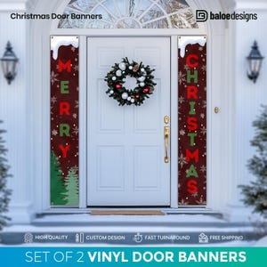 May include: Set of two vinyl door banners for Christmas. One banner says "Merry" in red letters with green snowflakes and pine trees on a brown background. The other banner says "Christmas" in red letters with green snowflakes and pine trees on a brown background.