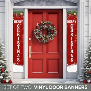 May include: Set of two red vinyl door banners with the text "Merry Christmas" in white. The banners are decorated with gold glitter and snowflakes. The banners are hanging on a red door with a Christmas wreath.