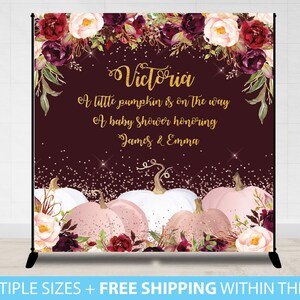 May include: A burgundy backdrop with gold glitter and floral accents. The text "Victoria A little pumpkin is on the way A baby shower honoring James & Emma" is written in gold script.  There are pink and white pumpkins with gold glitter accents.