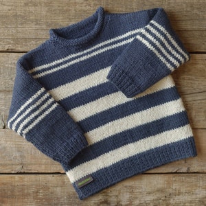 Può includere: Un maglione a righe blu e bianche in maglia con collo rotondo.