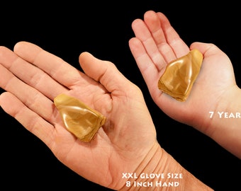 May include: Two hands holding a light brown, smooth, irregularly shaped stone. The hand on the left is an adult hand with an 8 inch circumference. The hand on the right is a child's hand, 7 years old.