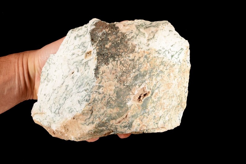 May include: A large, irregularly shaped rock with a white, tan, and green mottled pattern. The rock has a rough, uneven surface.