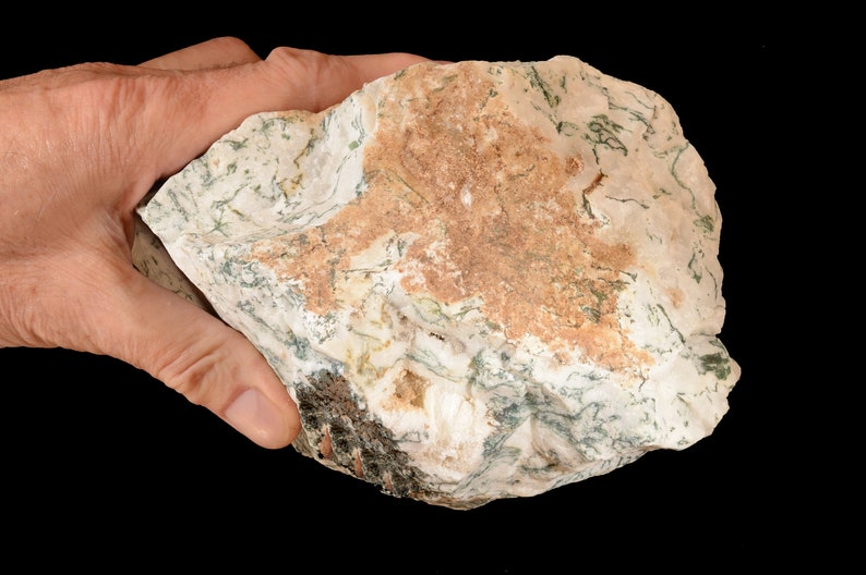May include: A large, irregularly shaped rock with a white, green, and brown mottled pattern. The rock has a rough, natural texture.