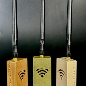 May include: Three rectangular electronic devices with black antennas. The left device is bronze with "WiFi Chat" text, the center is gold, and the right is beige with "192.168.4.1" text. Each unit features a cut-out Wi-Fi signal icon on the front face.