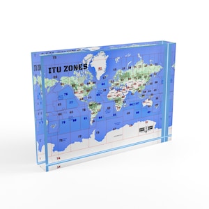 May include: A rectangular, transparent block displaying a world map with blue oceans, green landmasses, and numbered zones. The text "ITU ZONES" is visible. The map includes the continent of Antarctica.