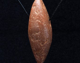 Antik jaspispärlhänge • Neolitisk handskuren stenamulett. 76 x 26 mm. Sahara, Västafrika