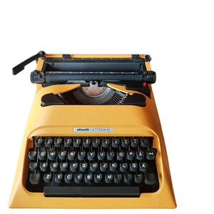 May include: A yellow Olivetti Lettera 10 typewriter with a black keyboard and a black carriage return lever.